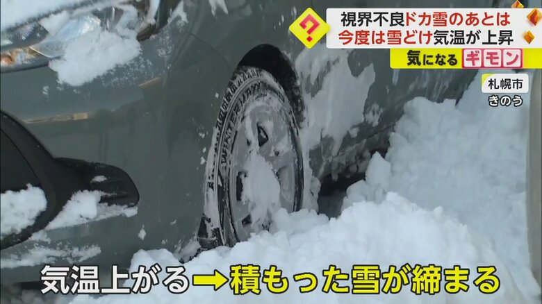 積もった雪でタイヤが空転する車