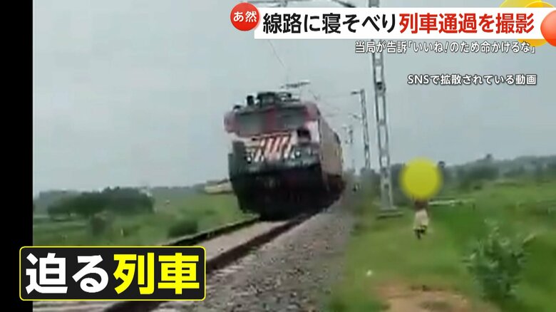 警笛が何度も鳴り響く中、寝そべる少年に迫る列車