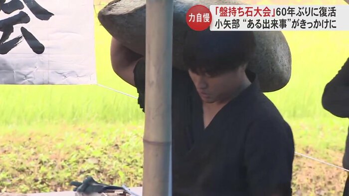 ひときわ大きな石を持ち上げる男性