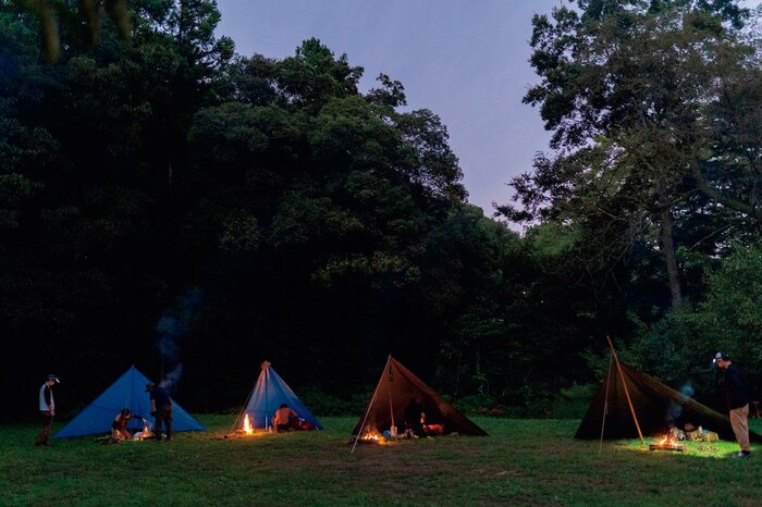 主催する「スマートキャンプラボ」では、焚き火とブルーシートで設営したシェルターで夜を過ごす（『焚き火の教科書』より）