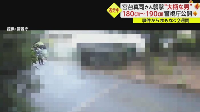 左側から小走りで現れたニット帽の男