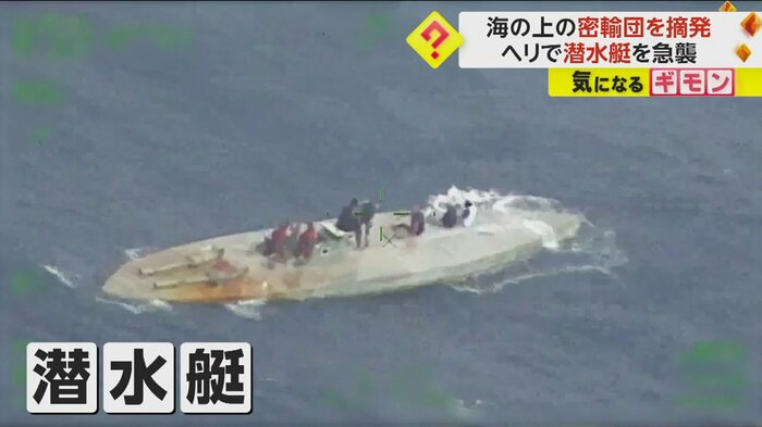 潜水艇の甲板に人が乗っている