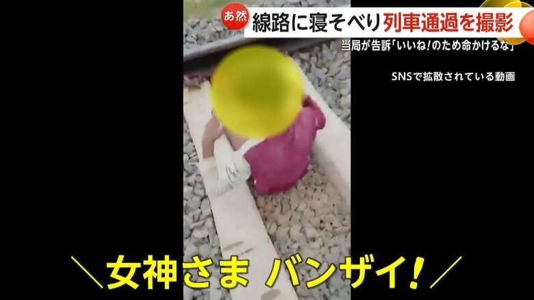 じっとしたまま、列車をやり過ごし、通過後に喜びをあらわにする少年