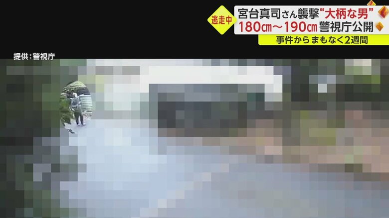 左側から小走りで現れたニット帽の男