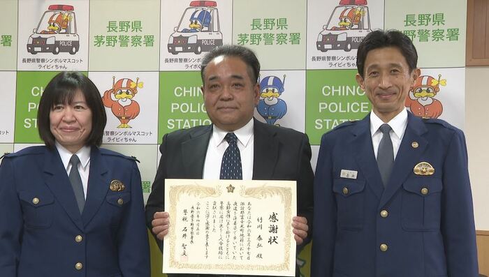 茅野警察署から感謝状を贈られた竹川泰弘さん(中央)