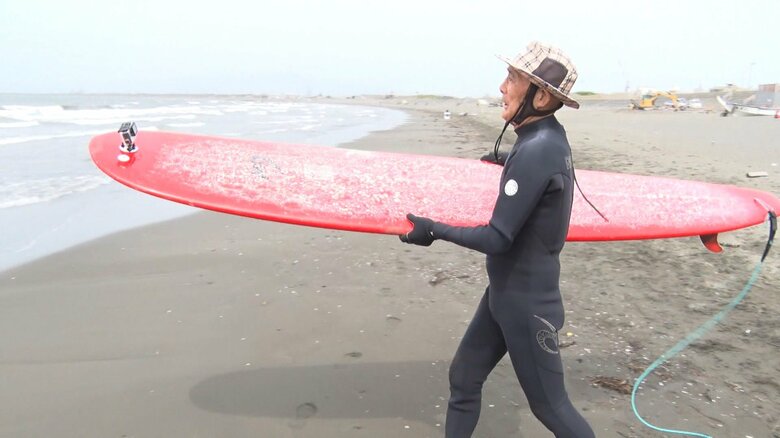 赤いサーフボードを持っていざ海へ