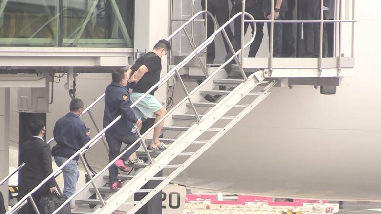 日本に向かう航空機に乗せられる今村磨人容疑者