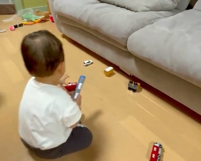 手前に来たおもちゃに手を伸ばす子ども