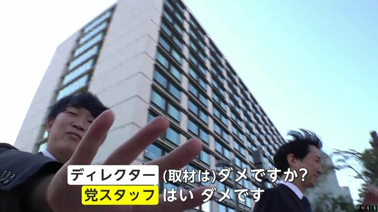 党の職員が間に入る形で取材をブロック