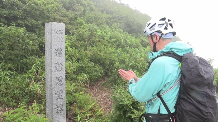 男鹿市・本山(標高715m)9合目にある慰霊碑に手を合わせる髙橋大輔さん