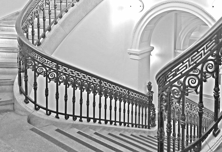 両側の小さなドームの下には階段が。非常に手の込んだ手すりで、曲線に沿って湾曲しながら登ってゆく、複雑で優雅な姿（『至高の近代建築』より）