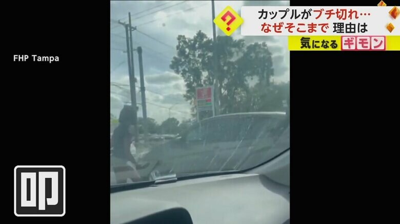 車内からの映像。男女2人が信号待ちの車の窓を叩く