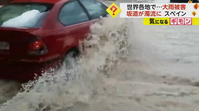 道を横切る赤い車。大量の水が車に当たっている（Jose Martinez）