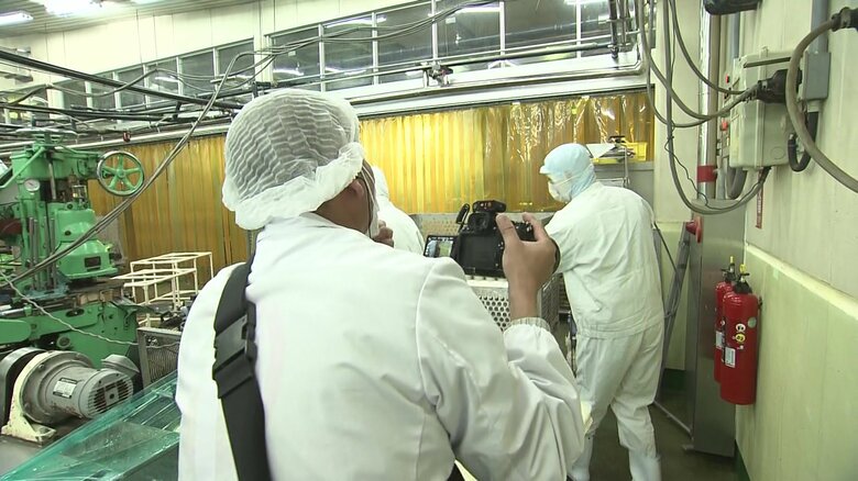 缶詰工場内でカメラを回す宮塚調査員