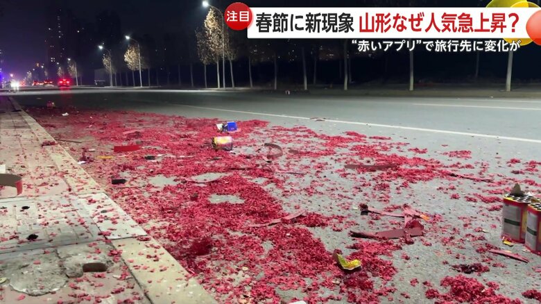 花火が終わるとごみとなった大量の爆竹が道路を真っ赤に染めていた