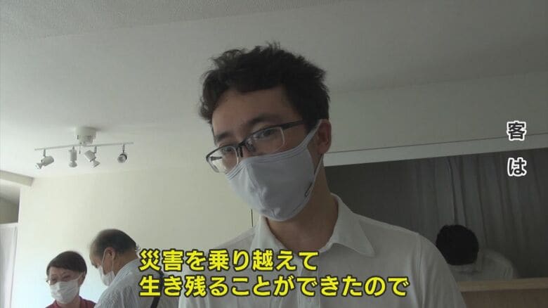 災害を乗り越え生き残った作品について話す客は…