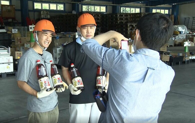 寄贈品を持ち記念写真を撮る中川さん（左）と長谷川さん（右）