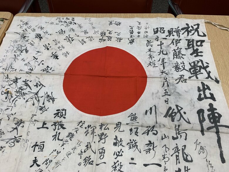 「祝聖戦出陣」と書かれた日章旗。「必勝」「頑張れ」という言葉も並ぶ。