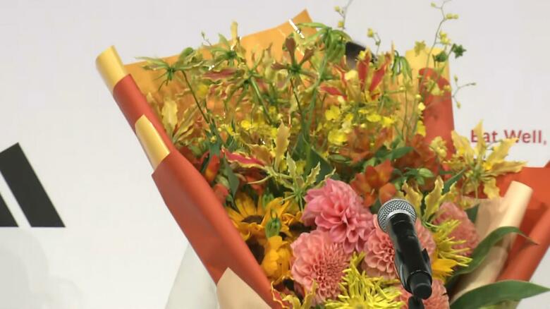 もらった花束で顔を隠す坂本花織選手(26)