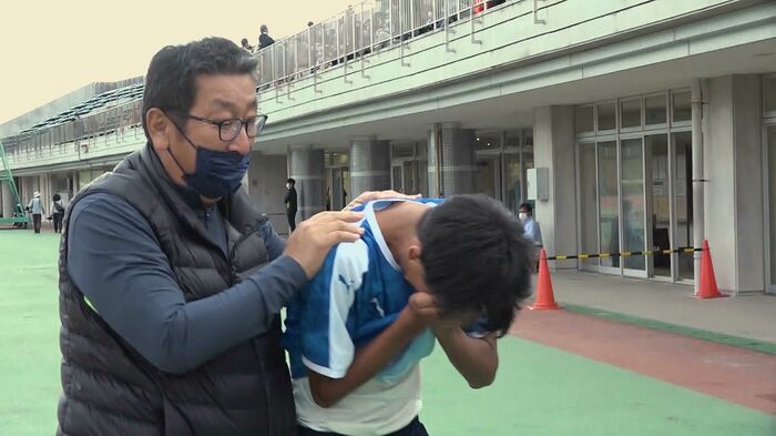 選手の肩を抱く山田監督