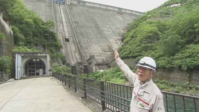 ダムを案内する伊藤俊樹 館長