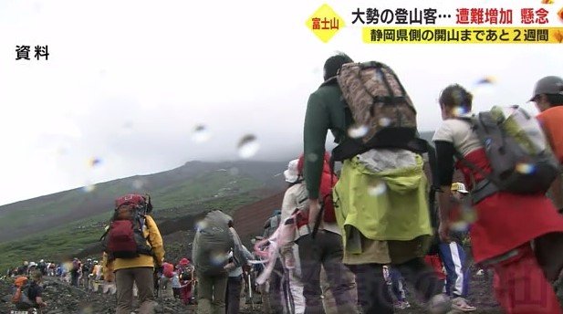 装備などの荷物を背負う登山客
