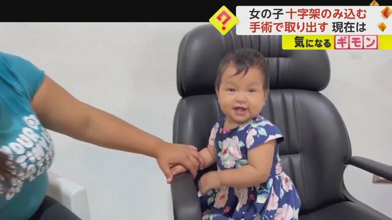 イスに座り、笑顔を見せる女の子