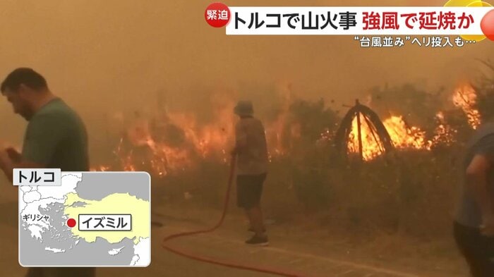 住民が家庭用ホースで消火にあたっている様子