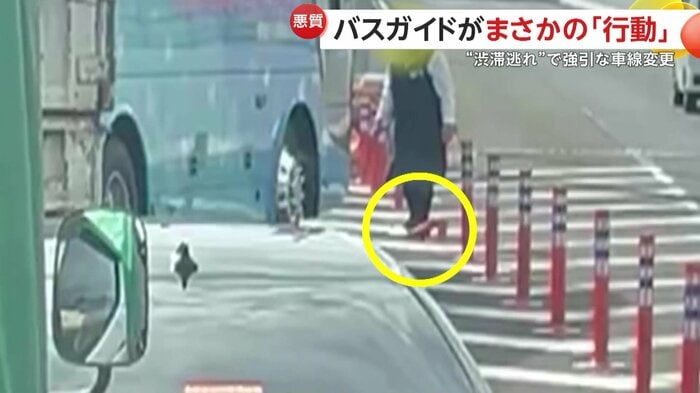 ラバーポールを踏みつけて折り曲げるバスガイド