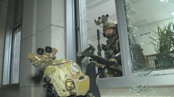 国会議事堂の窓ガラスを割り建物内に進入する兵士