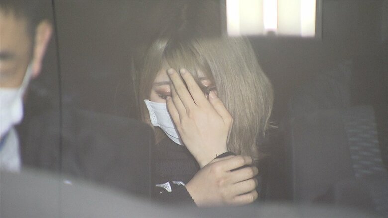 新宿署から移送される畠容疑者。報道カメラに気づくと、手で顔を隠す仕草を見せた。