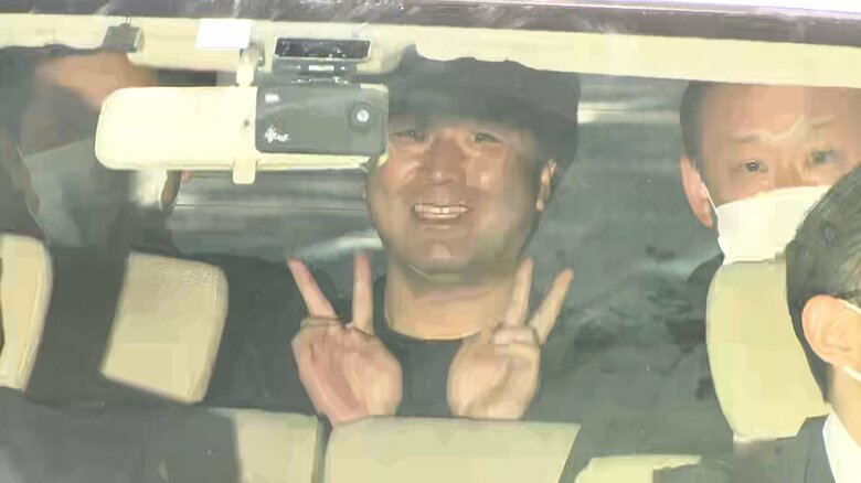 笑顔でピースサインを見せ警視庁に入るつばさの党代表・黒川容疑者　5月17日