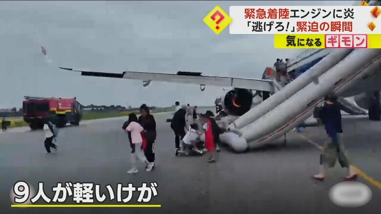 緊急脱出用のすべり台を下り、旅客機から脱出する人々