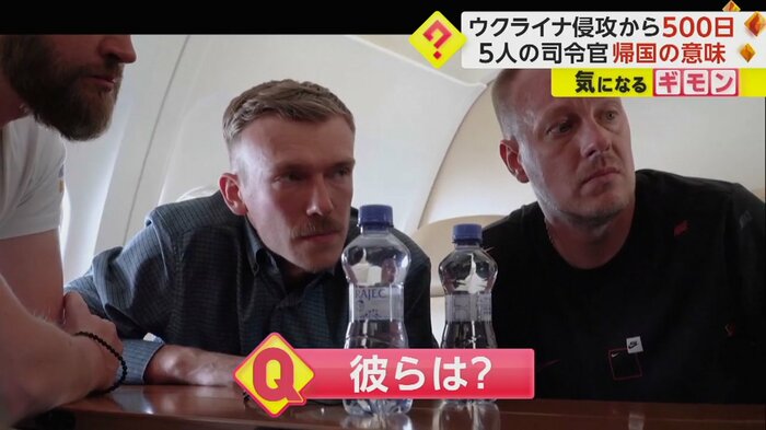 ゼレンスキー大統領が記念碑にメッセージを書き込む様子を見つめる男性たち