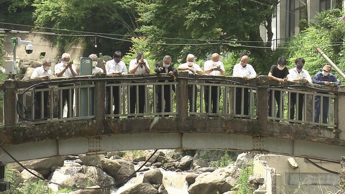 追悼式では川に菊の花を投げ入れ、4人の冥福を祈った