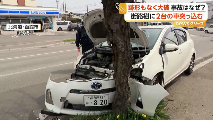 ボンネットが大きくめくれ上がっている白い車