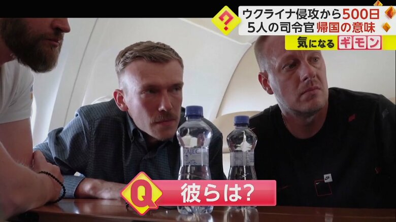 ゼレンスキー大統領が記念碑にメッセージを書き込む様子を見つめる男性たち