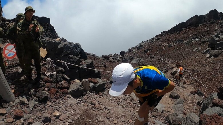 太ももを押さえながらなんとか登る小川さん