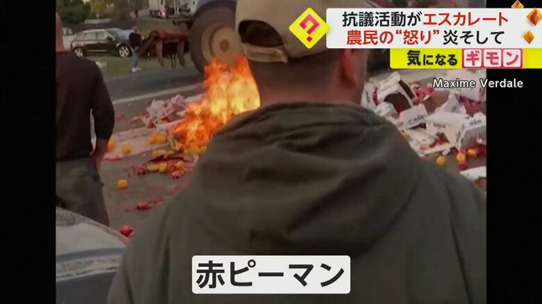 火のついたトラックの手前に、大量の赤ピーマンが散乱