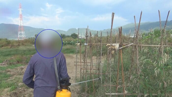 記者の質問を避け、その場を立ち去ろうとする男性