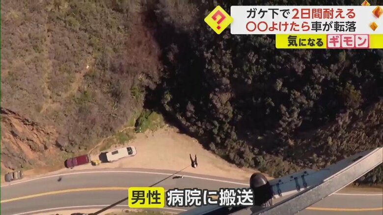 救助され道路へと降りていく男性