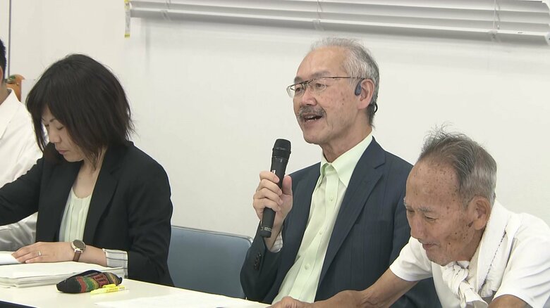 原告側　足立修一弁護士（真ん中）