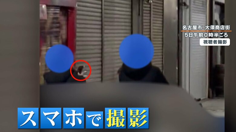 スマートフォンを取り出し、撮影するようなしぐさをする人