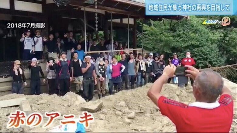 春日神社で復興ボランティアの写真を撮影する石田さん