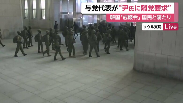 窓ガラスを割って侵入する兵士