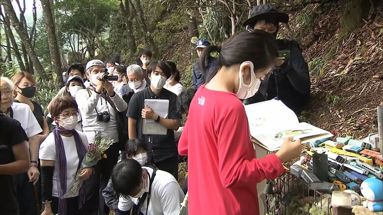 墓標の前で絵本の読み聞かせが行われた