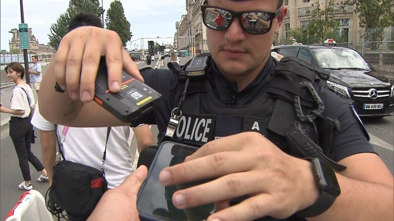 筆者がQRコードを求められる場面（開会式当日セーヌ川沿いオルセー美術館付近）