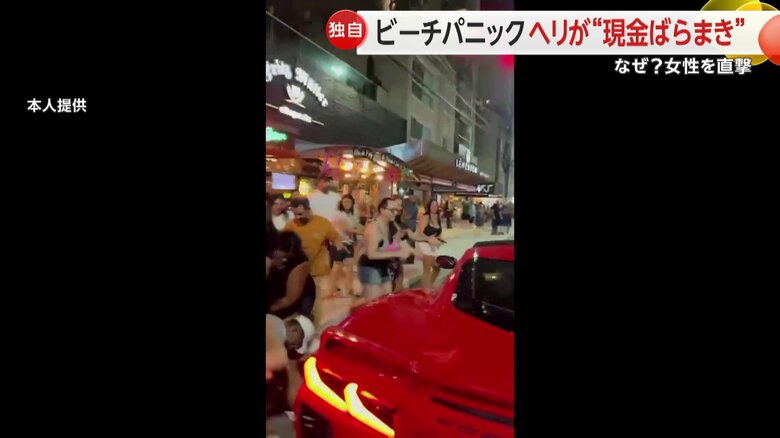 赤いオープンからお金がばらまかれる様子