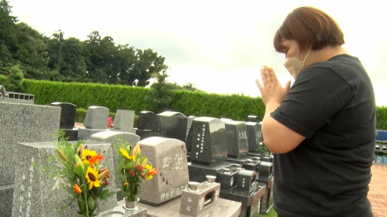 恩師の墓参りで手を合わせる冨田