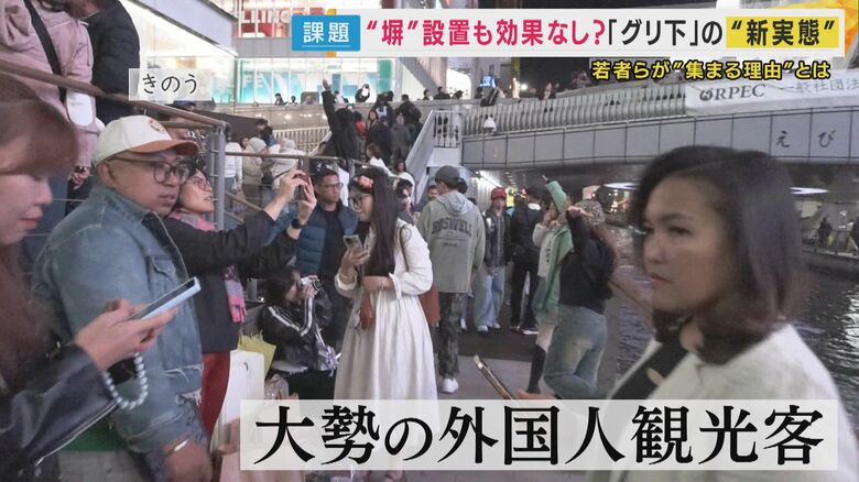 “塀”の周りには通路を塞ぐほど大勢の外国人観光客が